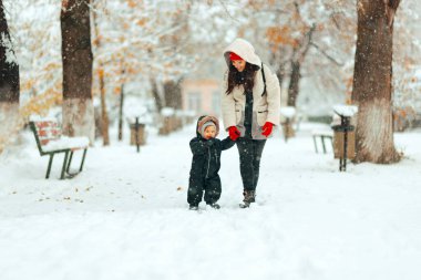 Anne ve Küçük Bebek Karda Birlikte Yürüyorlar 
