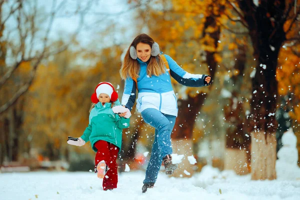 冬のシーズンに雪の中で遊ぶハッピーマザーと娘 — ストック写真