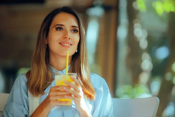 Happy Woman Drinking a Lemonade in a Restaurant