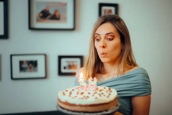 Woman Blowing Candles on a Homemade Cake for her Anniversary
