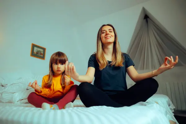 Happy Mother and Daughter Sitting in Yoga Pose at Home