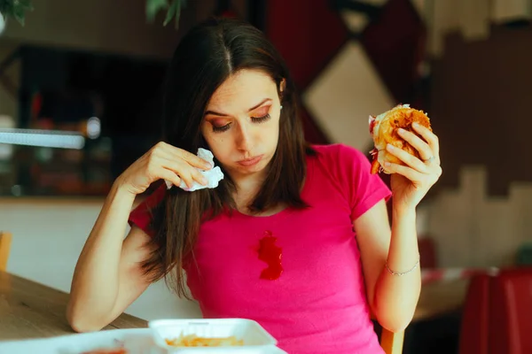 Woman Eating Burger Staining Herself with ketchup