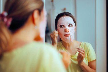 Aynaya Bakan Kadın Güzellik Çarşafı Maskesi Kullanıyor