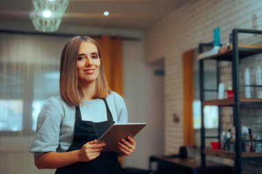 Kuaför kuaförde bilgisayar tableti tutuyor, kuaförde randevu veriyor.