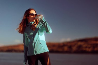 Sportif Kadın Koştuktan sonra Dışarıda Su İçiyor 