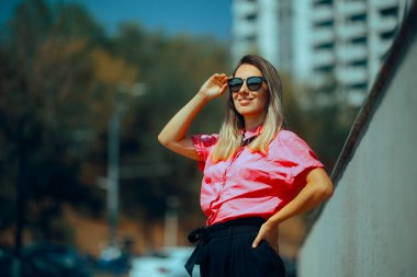 Güneş gözlüğü takan ve Pembe Gömlekli Moda Şehir Kadını