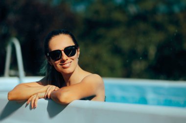 Arka bahçesinde güneş gözlüğü takan güzel bir kadın. 