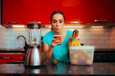Telefonunda meyve püresi tarifi arayan bir kadın. 