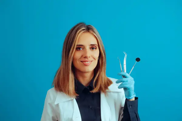 Zahnarzt Hält Medizinische Instrumente Auf Blauem Hintergrund — Stockfoto