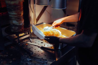 Fast Food Cook tepsiden taze patates kızartması alıyor. 