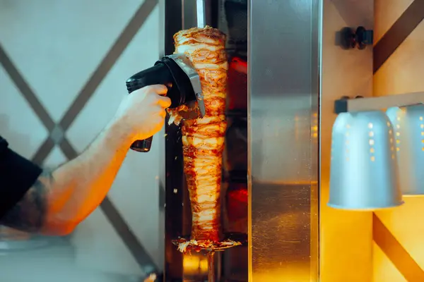 Rotisserie Fast Food Worker Using a Cordless Meat Slicer Machine
