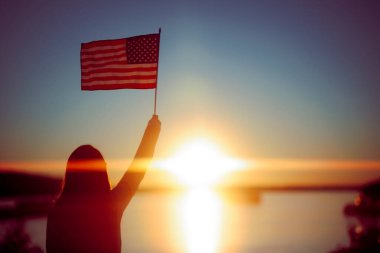 Güneş Işığında Amerikan Bayrağı Tutan Kadın 