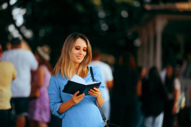 Halka açık bir etkinlikte kadın ajandasını kontrol ediyor. 