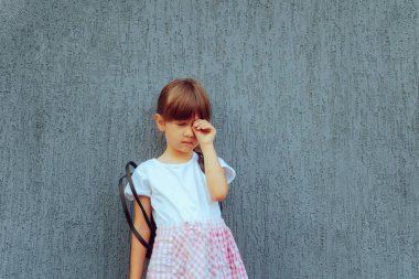 Okula döndüğü için ağlayan mutsuz kız.