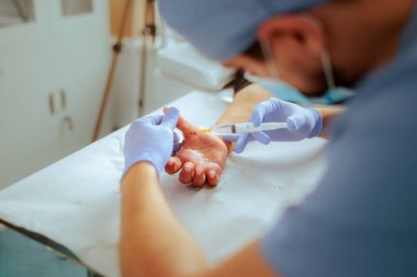 Doktor Cerrahi Hastanın Başparmağını Enjekte Ediyor 