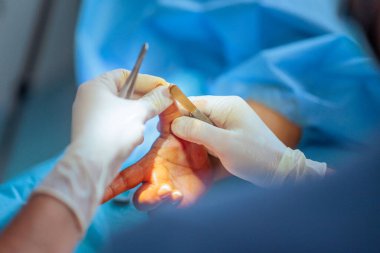 Ortopedik cerrah hastanın elini tutuyor.