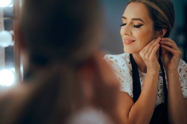 Kadın küpelerini kapatıyor Aynaya bakıyor 