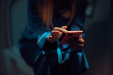 Tuvalette otururken telefonunu kontrol eden kişi. 