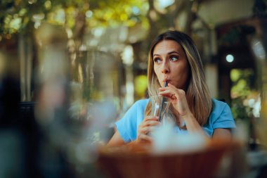 Restoranda limonata içen bir kadın. 