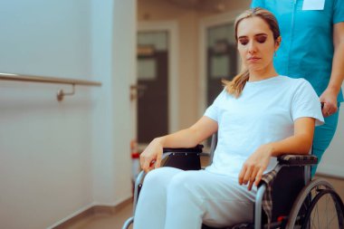 Nurse Pushing a Female Patient with a Wheelchair in a Hospital  clipart