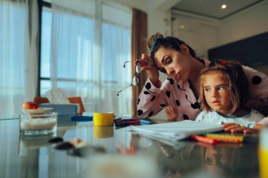 Küçük kızıyla ev aktiviteleri yapmaktan bıkmış bir anne.