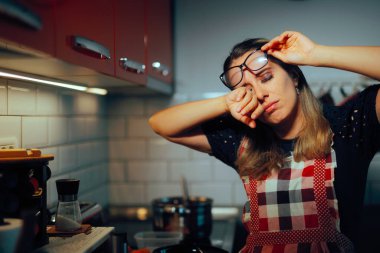 Aşçı kadın, sulu gözlü, kadehini kaldıran.  
