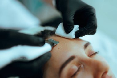 Güzellik uzmanı cilt soyma için ultrasonik yüz temizleme cihazı kullanıyor.