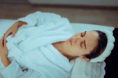 Bornoz giyen bir kadın Spa 'da dinleniyor.