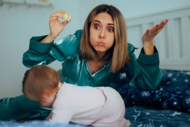 Anne hiperaktif bir bebeğin tırnaklarını kesmeye çalışıyor.