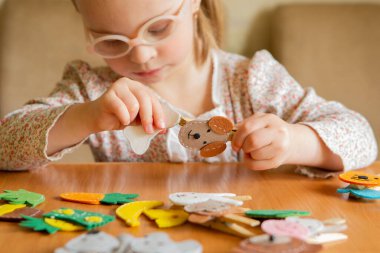 A girl with Down syndrome develops fine motor skills. Pin, dog