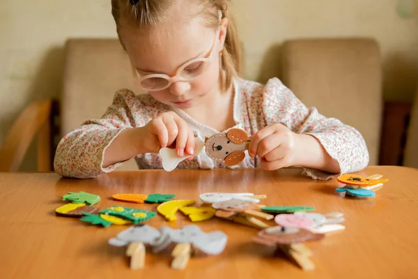 A girl with Down syndrome develops fine motor skills. Pin, dog