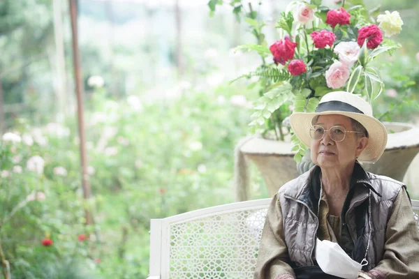 老年老年老年妇女坐在玫瑰花园公园休息放松 — 图库照片