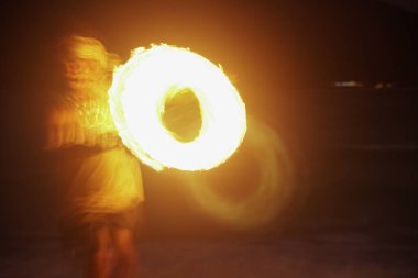 Sahilde gece ateşle dans eden bir adam.