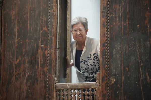 stock image asian old elderly elder senior woman smiling at window