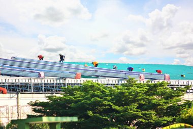 group of worker are installing metal sheet roof on steel structure