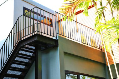 Siyah metal merdivenler ve çitler tatil köyü binasının ikinci katında.