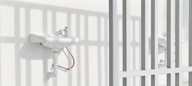 Beyaz seramik lavabonun gölgesi duvara kurulur.