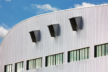 Fabrika deposunun havalandırma delikleri olan yuvarlak metal duvar.