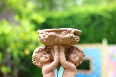 Bir erkek ve bir kızın heykelini kapatıyoruz. Bahçede sevgi dolu bir ruh hali içinde küçük bir açı.