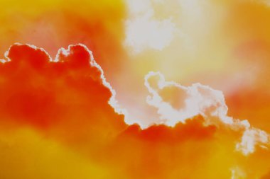 Güneş parlak soyut bulut şekilli arka planda parlarken turuncu bulutlar gökyüzünü kararttı.