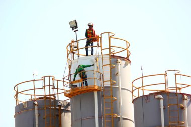 İşçiler çelik tankı yeniliyorlar.