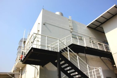 Düşük açılı çelik yapı geçidi yan binadan zemin kata kuruluyor. Acil durum çıkışı çelik merdiven kontrol yasasına göre binanın dışına yürüyün.