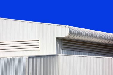 Mimari tasarım eğrisi şekli kıvrımlı duvar geometrik binası. Fabrika deposu, mavi gökyüzüne karşı ilgi uyandırmak için dokularla kaplanmış.