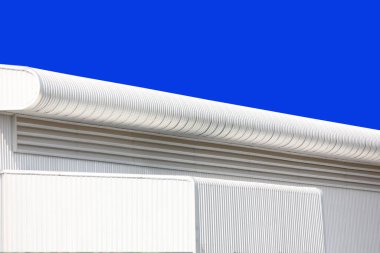 Mimari tasarım eğrisi şekli kıvrımlı duvar geometrik binası. Fabrika deposu, mavi gökyüzüne karşı ilgi uyandırmak için dokularla kaplanmış.