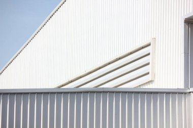 Mimari tasarım eğrisi şekli kıvrımlı duvar geometrik binası. Fabrika deposu, mavi gökyüzüne karşı ilgi uyandırmak için dokularla kaplanmış.