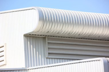 Mimari tasarım eğrisi şekli kıvrımlı duvar geometrik binası. Fabrika deposu, mavi gökyüzüne karşı ilgi uyandırmak için dokularla kaplanmış.