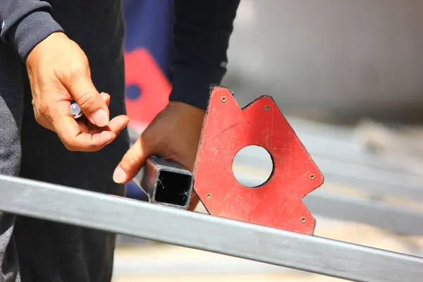 Kaynakçı kaynaklamadan önce bileşenleri konumlandırmak için bir manyetik kaynak tutucu kullanıyor