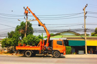 Elektirik işçisi havadaki vinci kontrol ediyor. Bir işçiyi elektrik direği üzerine çalışmaya götür.