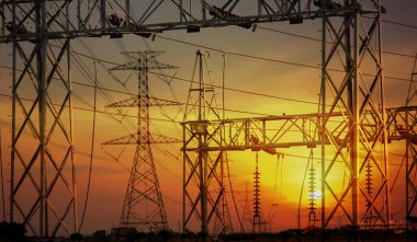 Kırsal kesimdeki yüksek voltajlı elektrik direğinden güç konvertör istasyonu günbatımı doğa arka planına geçiş.