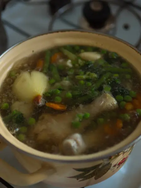 Stock image Chicken Soup in a Yellow Pot on the Stove. Vertical close up.